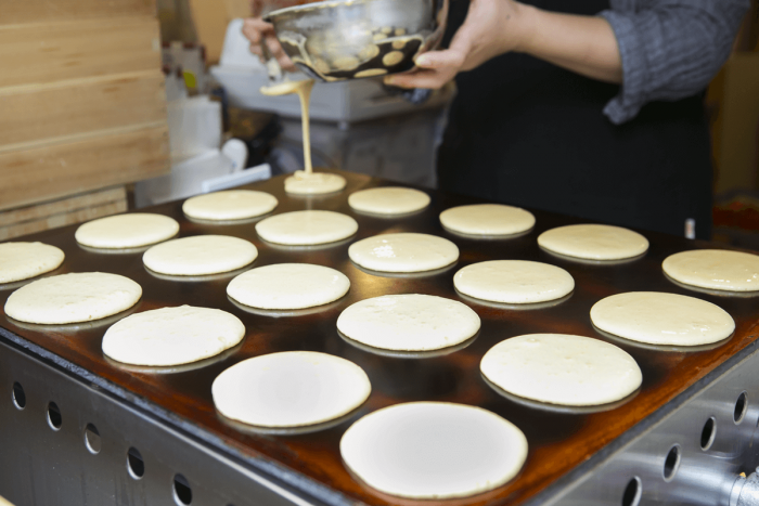 Batter is poured onto the griddle, evenly spaced and all the same size.